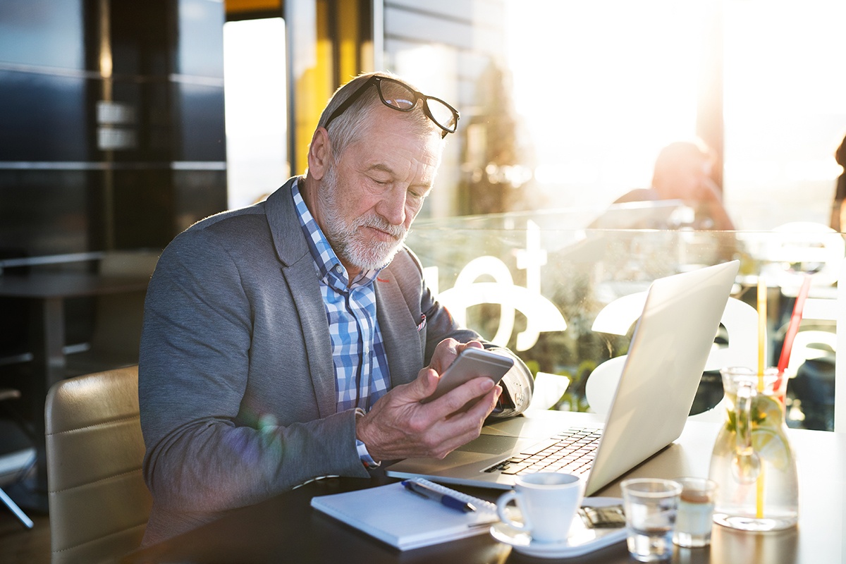 Businessman in cafe with smart phone and tablet